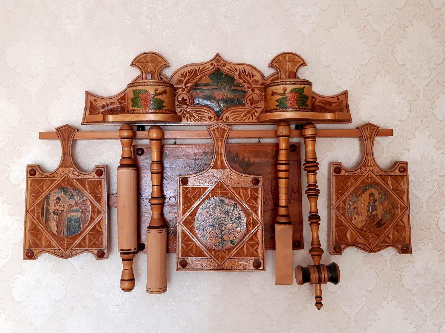 Utensili da cucina in legno intagliato appesi a una rastrelliera decorata